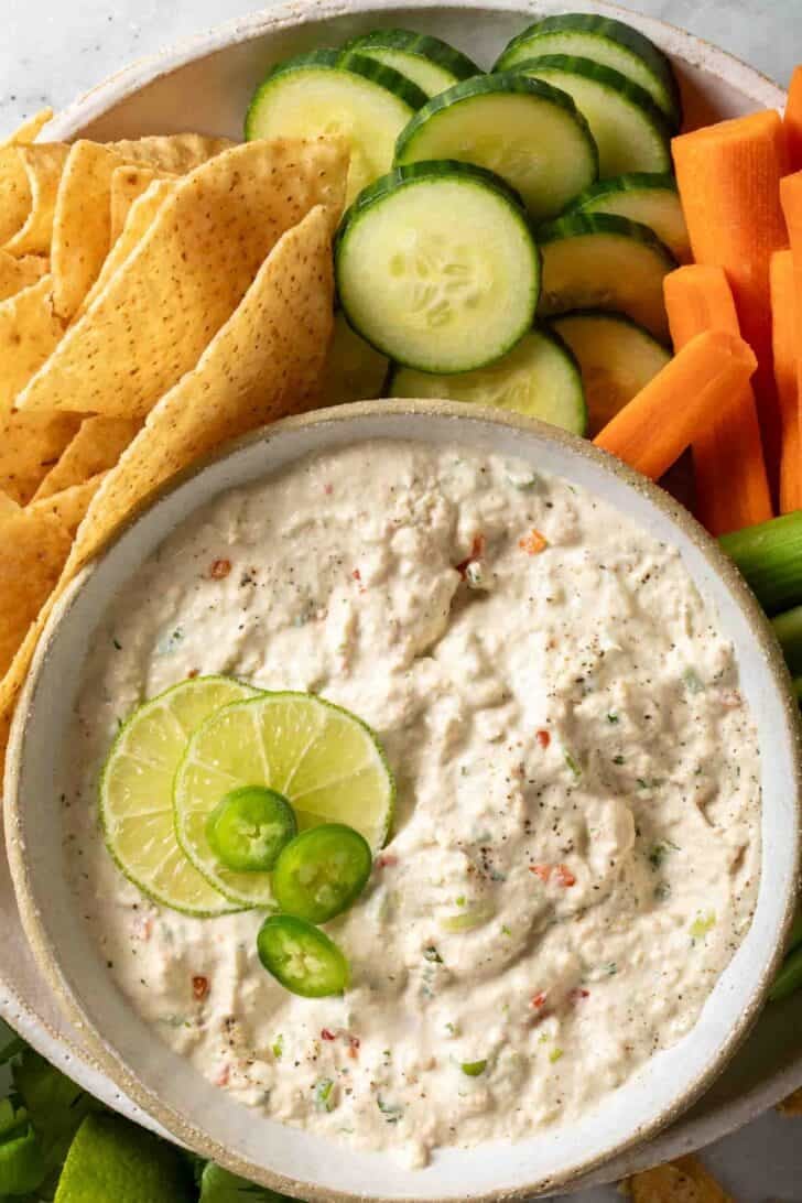 Tuna Dip Spicy Tuna Dip in a bowl next to tortilla chips, sliced cucumber, carrot and celery sticks.