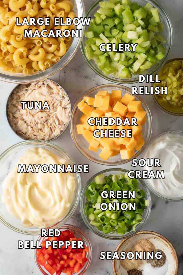 Tuna Macaroni Salad Recipe Clear glass bowls filled with macaroni, chopped celery, green onion, red pepper and cheese for a tuna macaroni salad recipe.