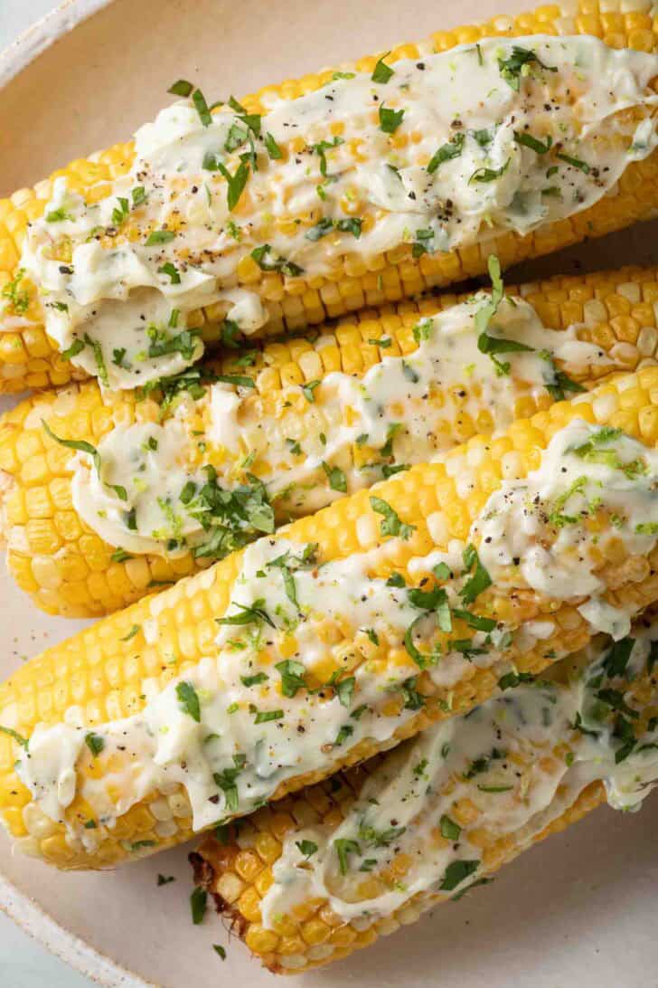Air Fryer Corn on the Cob Air Fryer Corn on the cob on a plate slathered with butter.