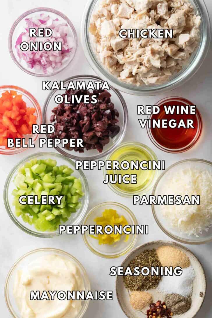 Italian Chicken Salad Recipe Clear glass bowls filled with chopped chicken, red onion, red bell peppers and kalamata olives for an Italian chicken salad recipe.