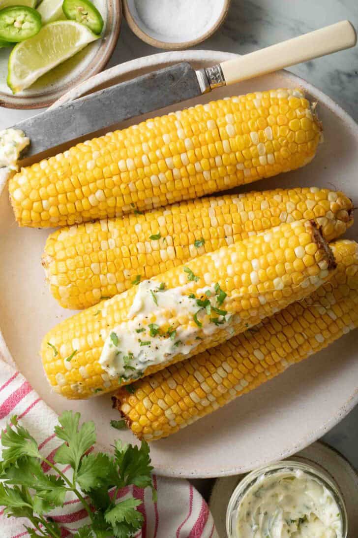 Air Fryer Corn on the Cob Air Fryer Corn on the Cob on a plate next to a jar of butter.