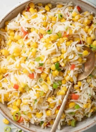 Corn Rice in a bowl with a serving spoon.