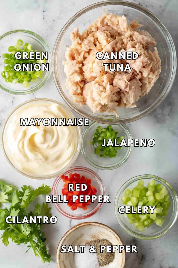 Clear glass bowls filled with canned tuna, mayonnaise, jalapeno and celery for Tuna Dip recipe.