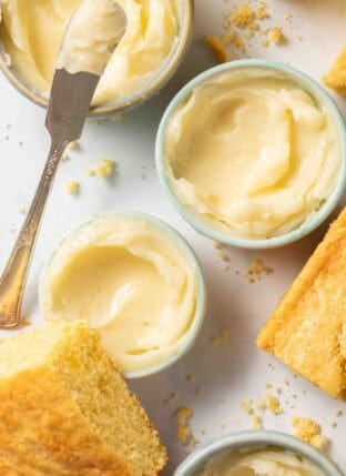 Homemade Whipped Honey Butter in small bowls next to cornbread.