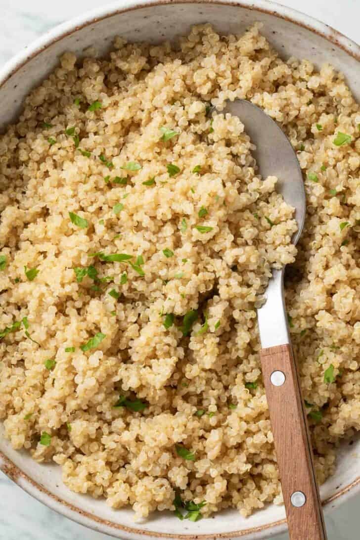 Rice Cooker Quinoa Rice Cooker Quinoa in a bowl with a serving spoon.