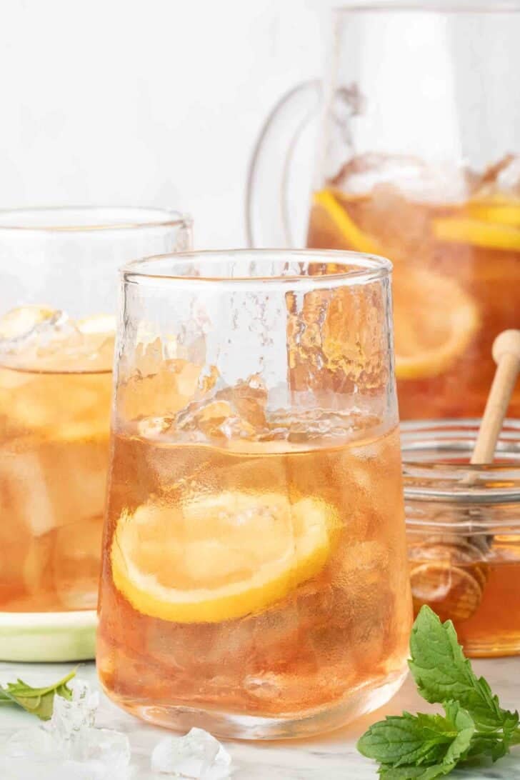 Best Iced Tea Two clear drinking glasses and a glass pitcher filled with the best iced tea.