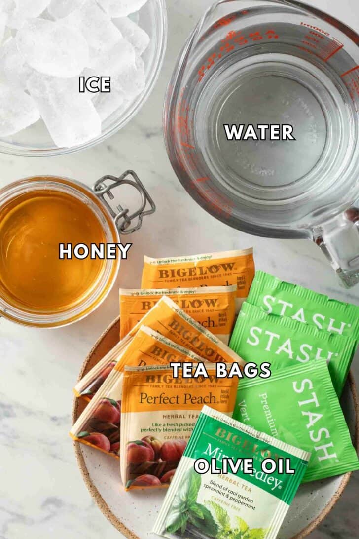 Iced Tea Recipe Water in a measuring cup next to tea bags, a bowl of ice and a jar of honey for How to Make Iced Tea Recipe.