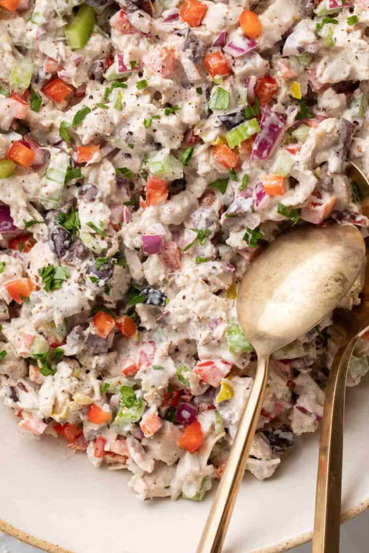 Italian Style Chicken Salad Italian style chicken salad in a bowl with two serving spoons.