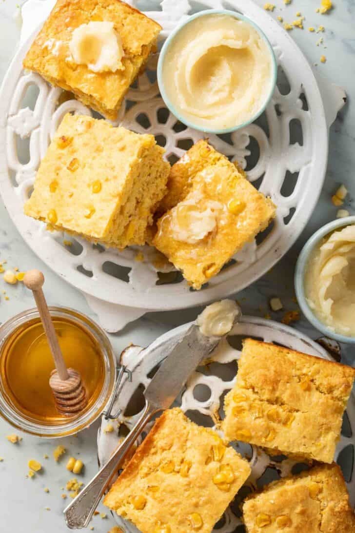 Old Fashioned Cornbread Cut square pieces of Old Fashioned Cornbread on white cooling racks.