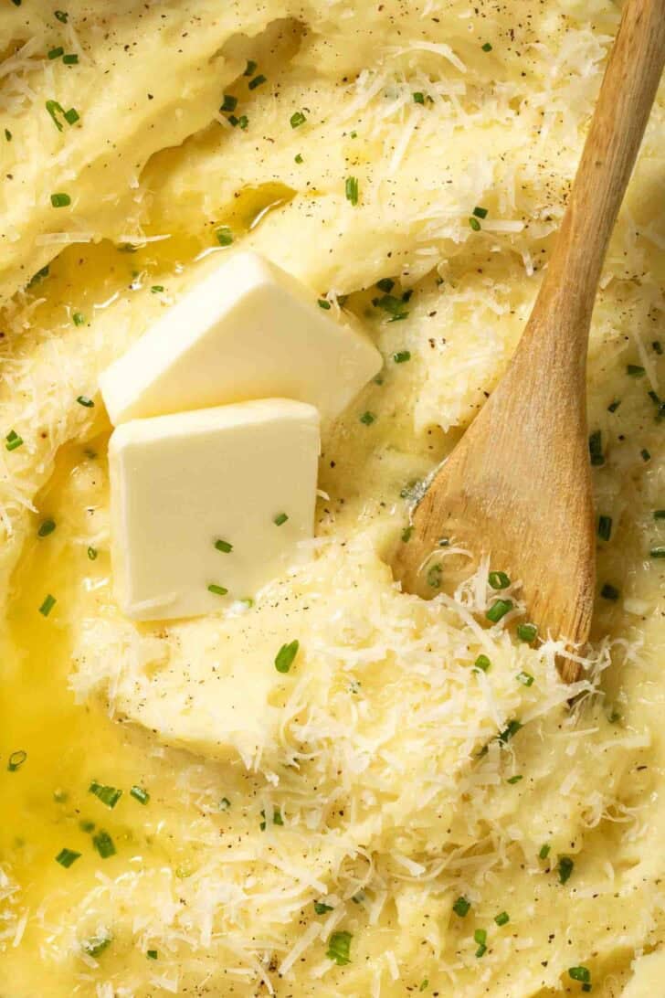Parmesan Mashed Potatoes Parmesan Mashed Potatoes in a pot with melted butter on top.