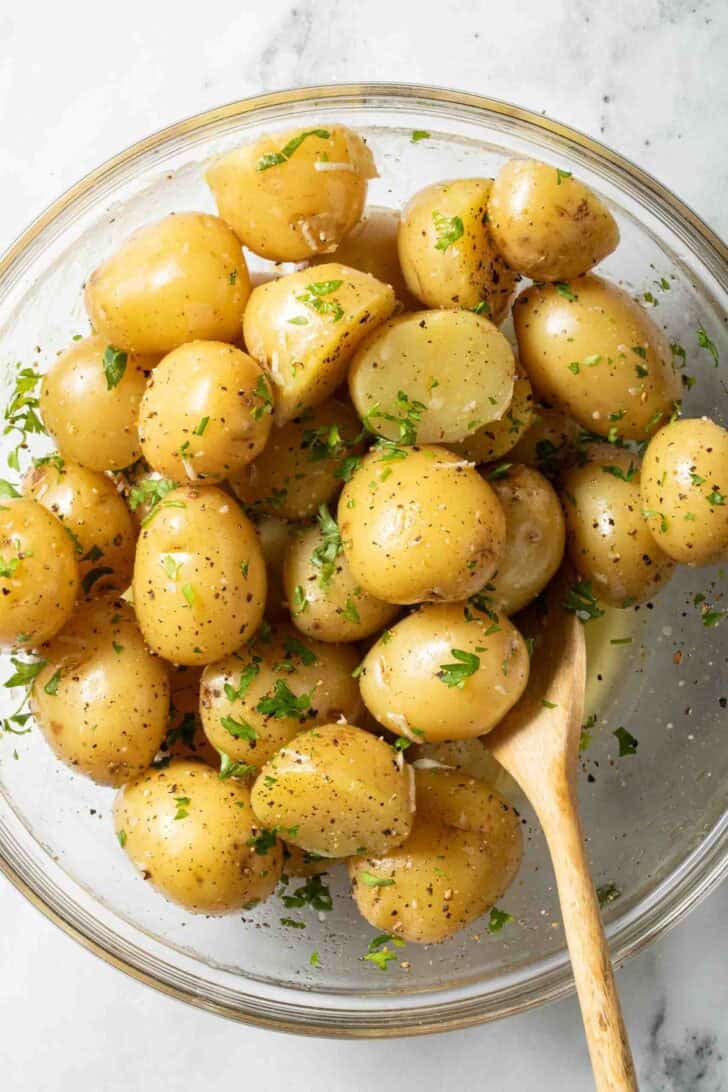 Boiled Potatoes and Butter Boiled Potatoes and Butter in a clear glass bowl with a wooden spoon.