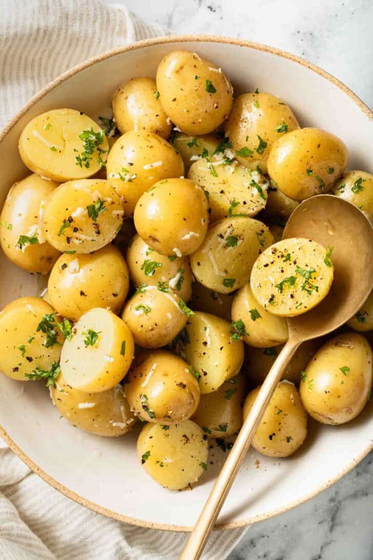 Boiled Potatoes and Butter Boiled Potatoes and Butter in a white bowl with a gold serving spoon.