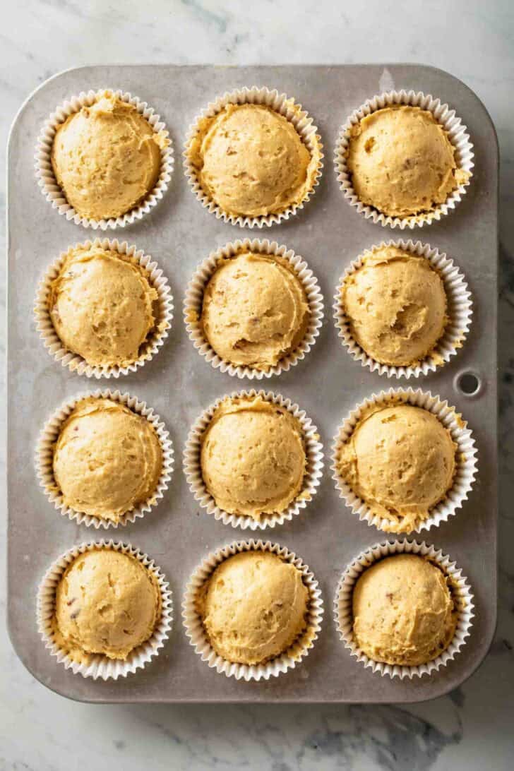How to Make Pumpkin Cream Cheese Muffins Pumpkin muffing batter in muffin tins.