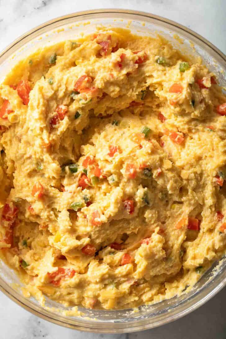 Jalapeno Cheddar Cornbread Muffins Jalapeno Cheddar Cornbread Muffins batter in a clear glass mixing bowl.