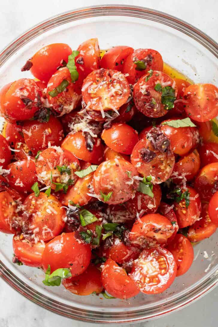 How to Make Marinated Tomatoes Marinated tomatoes in a clear glass bowl.