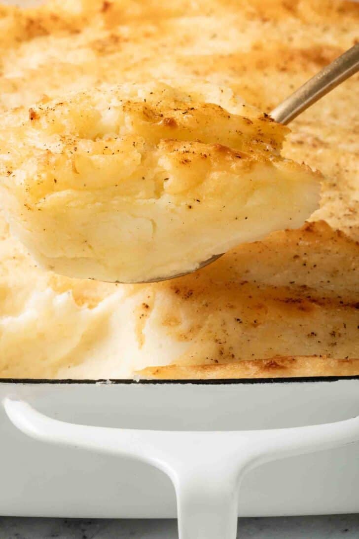 Baked Mashed Potatoes Recipe Baked Mashed Potatoes in a white baking dish.