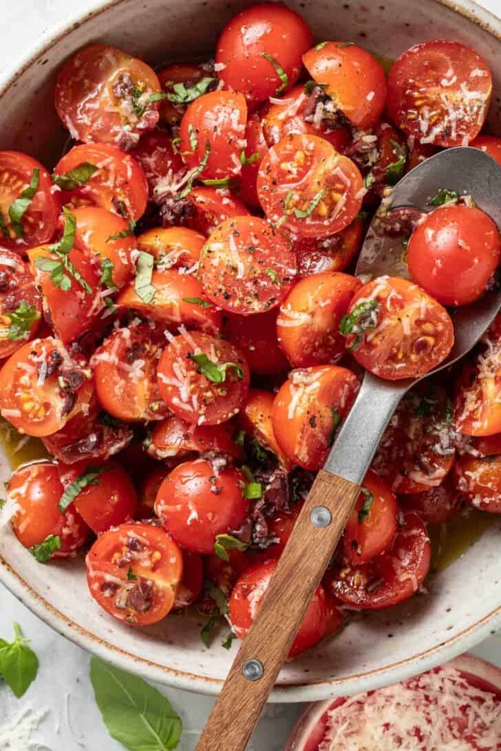 Marinated Cherry Tomatoes Marinated Cherry Tomatoes in a bowl with a serving spoon.