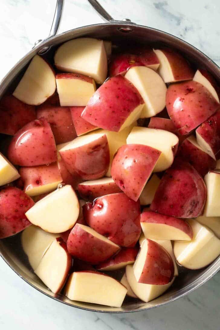 Red potatoes in a pot of water for mashed red potatoes recipe.