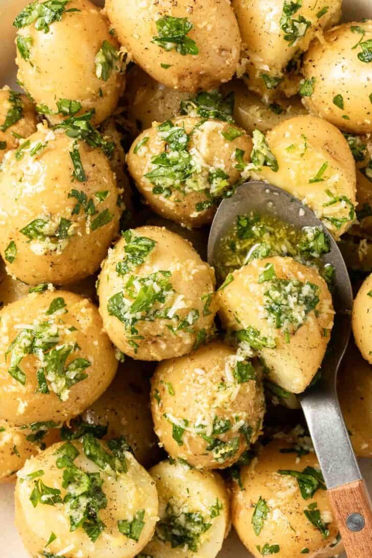Recipe for Parsley Potatoes Parsley Potatoes in a bowl with a serving spoon.