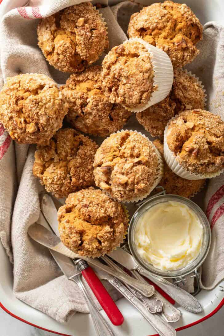 Pumpkin Spice Muffins Pumpkin Spice Muffins in a tray with a crock of butter.