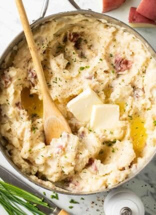 Red Mashed Potatoes in a pot with a wooden spoon.