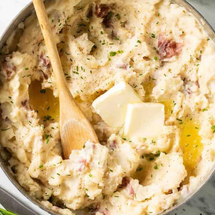 Red Mashed Potatoes in a pot with a wooden spoon.
