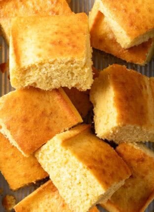 Wedges of Sweet Cornbread stacked in a baking dish.