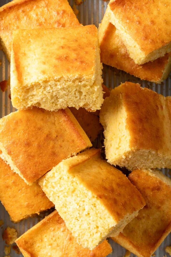 Best Sweet Cornbread Recipe Cut pieces of Sweet Cornbread stacked in a baking dish.
