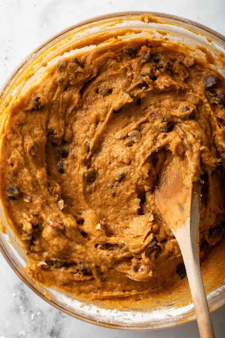 How to Make Pumpkin Muffins with Chocolate Chips Chocolate Chip Pumpkin Muffins batter in a clear glass mixing bowl.