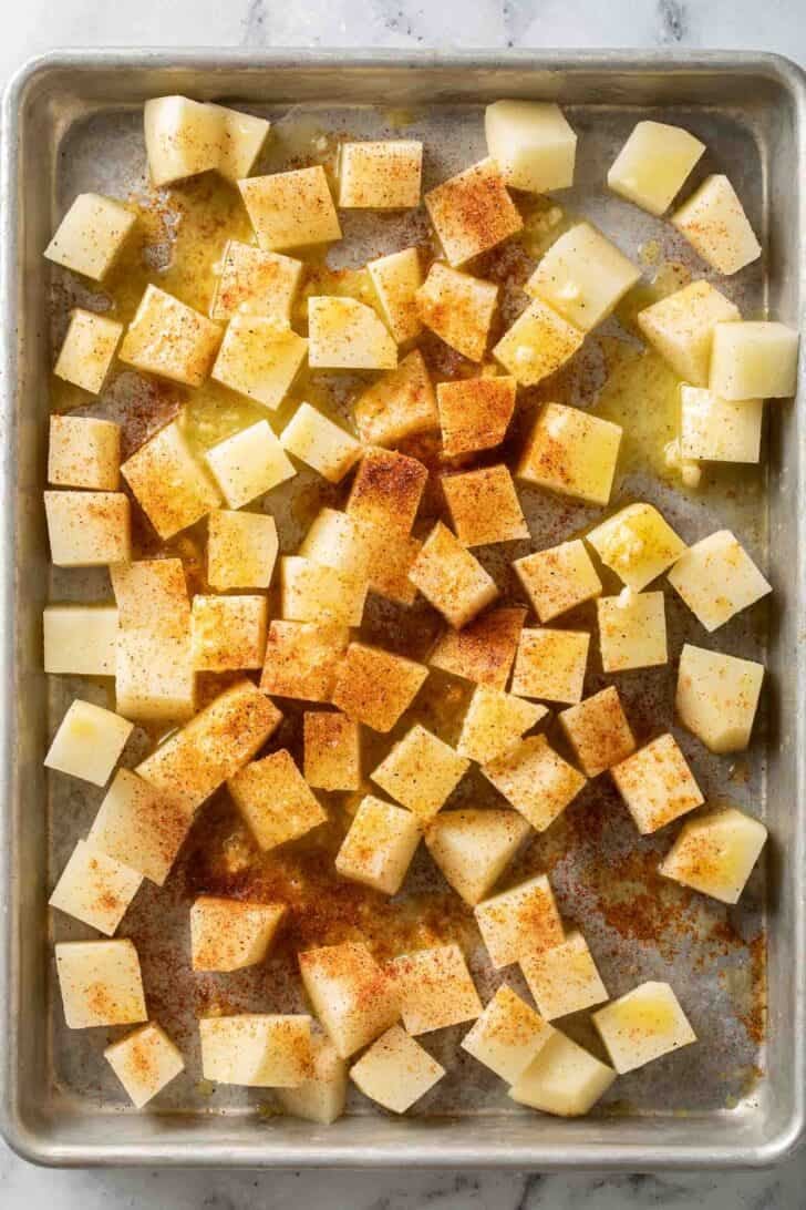 Mexican Potatoes Recipe Raw potatoes cut into cubes on a baking sheet for Mexican Potatoes Recipe.