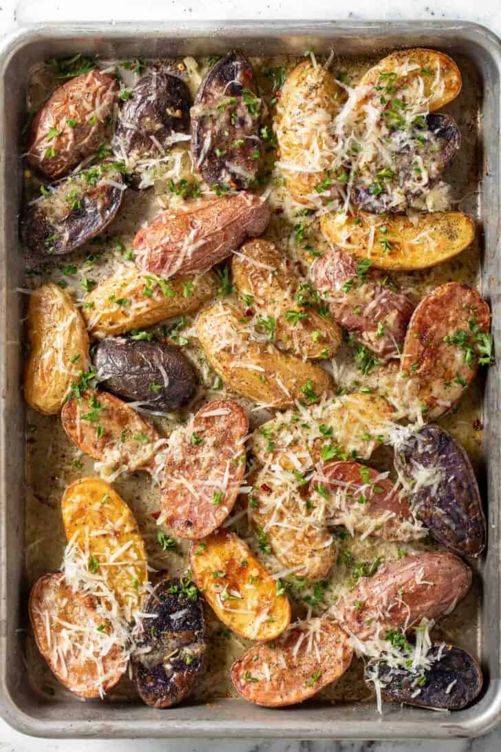 Fingerling Potatoes Recipe Roasted Fingerling Potatoes with grated parmesan cheese on a baking sheet.