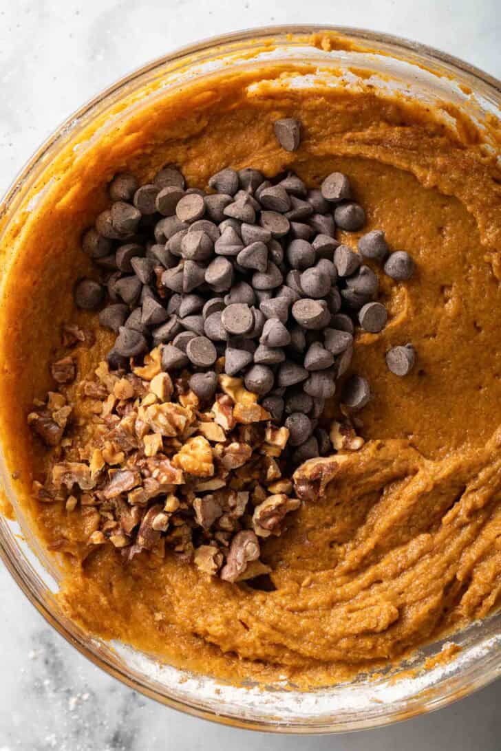 Pumpkin Chocolate Chip Muffins Pumpkin Chocolate Chip Muffins batter in a clear glass mixing bowl.