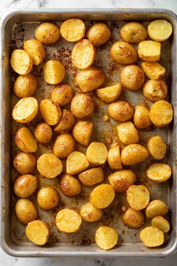 How to Make Roasted Roasted Potatoes and Green Beans Roasted baby Yukon gold potatoes on a baking sheet.