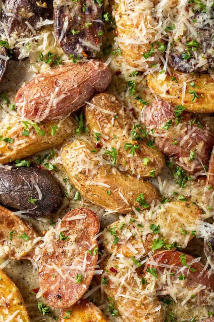 Roasted Fingerling Potatoes Recipe Roasted Fingerlings tossed in a lemon Dijon dressing and grated parmesan cheese on a baking sheet.