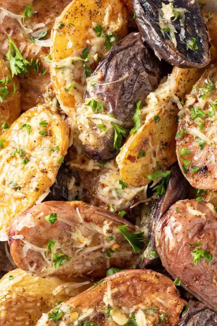 Roasting Fingerling Potatoes Roasted Fingerlings tossed with grated parmesan cheese on a baking sheet.