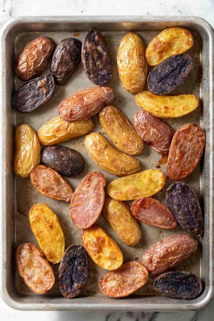 Roasting Fingerling Potatoes Roasted Fingerling Potatoes on a baking sheet.