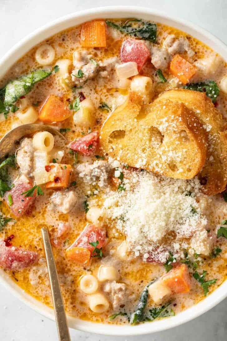 Creamy Parmesan Italian Sausage Soup Creamy Parmesan Italian Sausage Soup in a white bowl with a gold spoon.