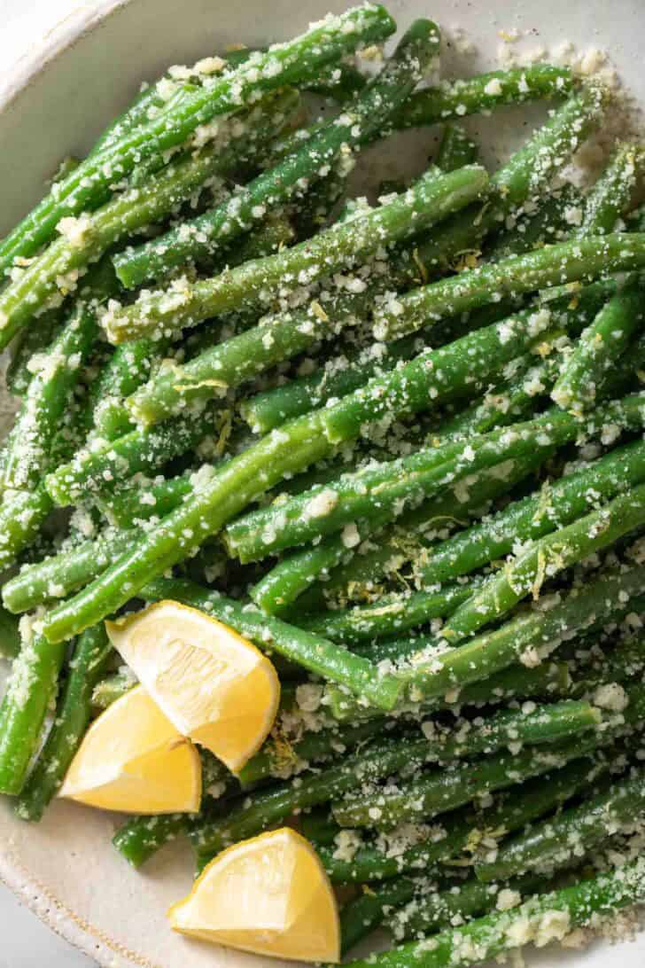 Garlic Green Beans Garlic Green Beans tossed with parmesan cheese in a white bowl.