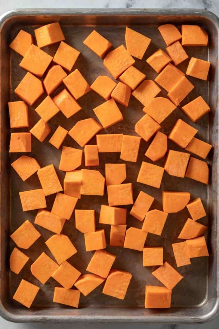How to Roast Sweet Potatoes Cubed sweet potatoes on a baking sheet.