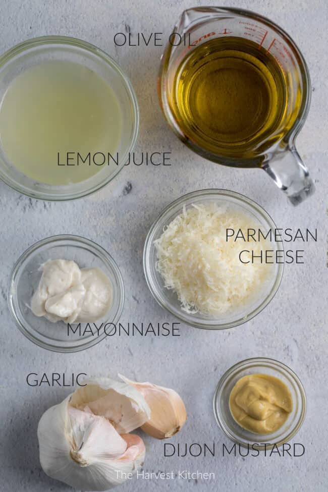 Several clear glass jars filled with ingredients for homemade vinaigrette.