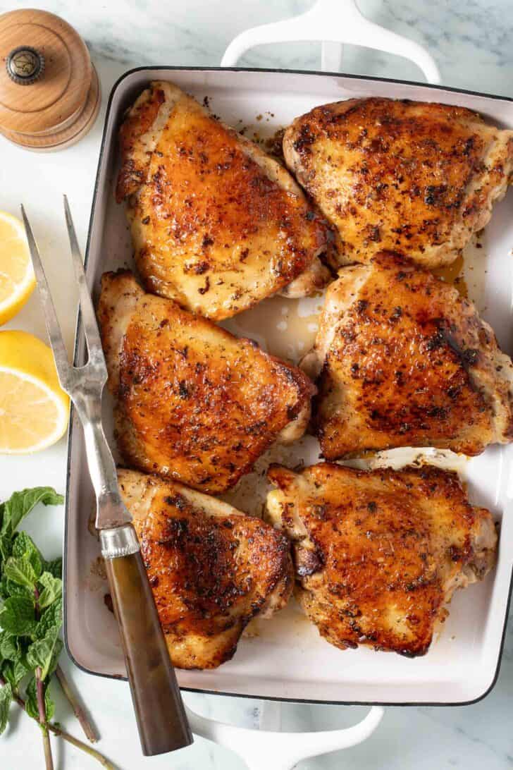 Greek Chicken Seasoning Marinated Greek chicken in a white baking dish.